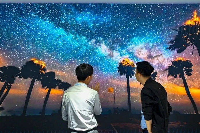 長春光博會希達電子展區(qū)，一位工作人員正在給一位觀眾講解。（長春新區(qū)供圖）