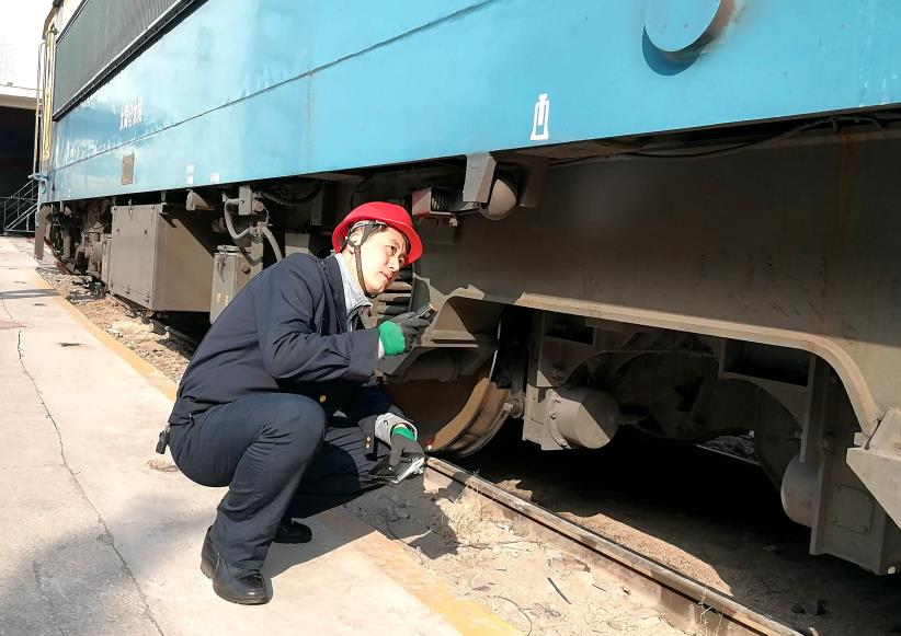 韓文盛全神貫注檢查機(jī)車走行部。