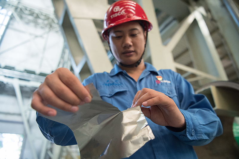 2018年8月8日，山西省太原市，太鋼精密帶鋼公司工作人員用手撕開不銹鋼。