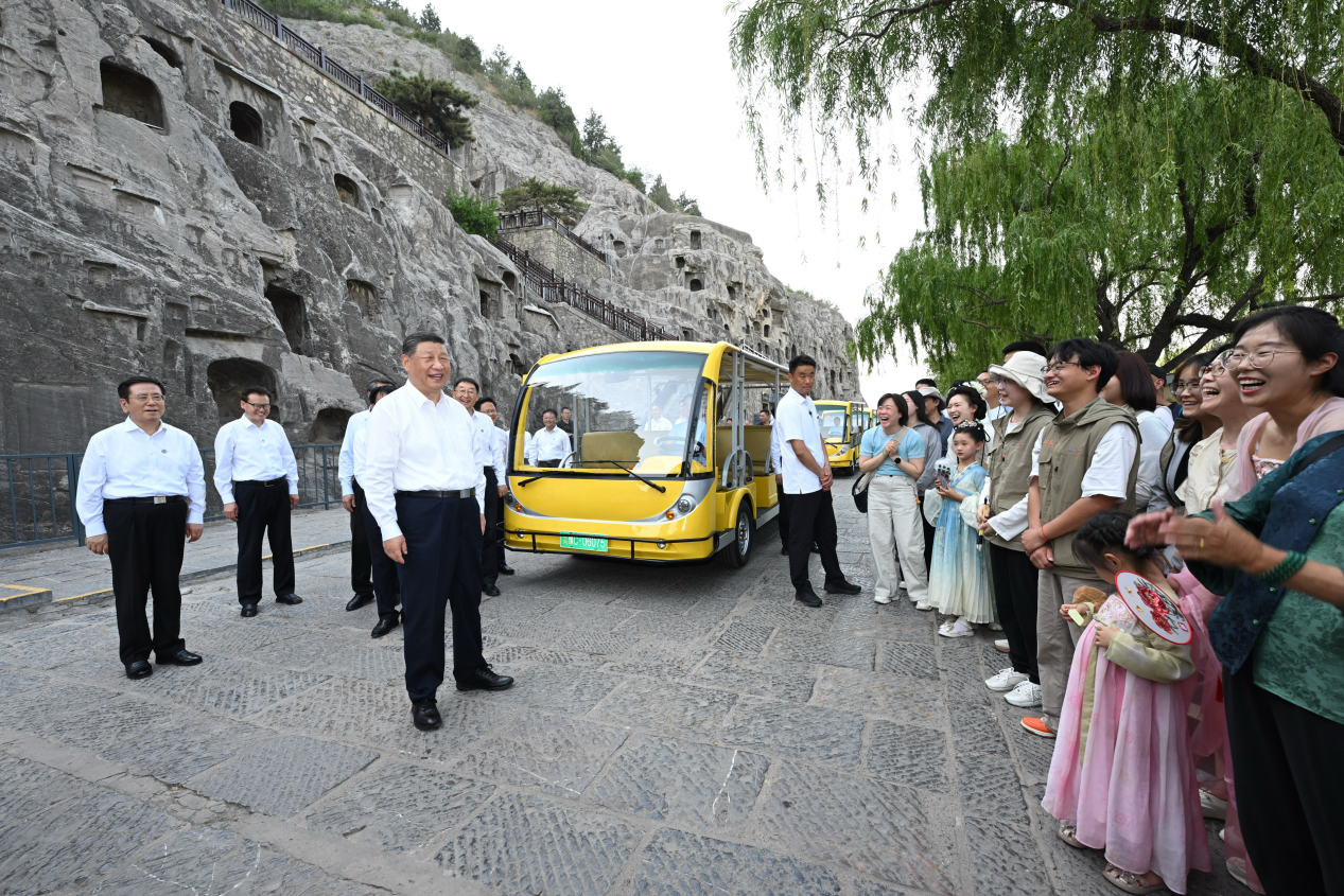 5月19日，習(xí)近平在洛陽龍門石窟考察時，同游客親切交流。