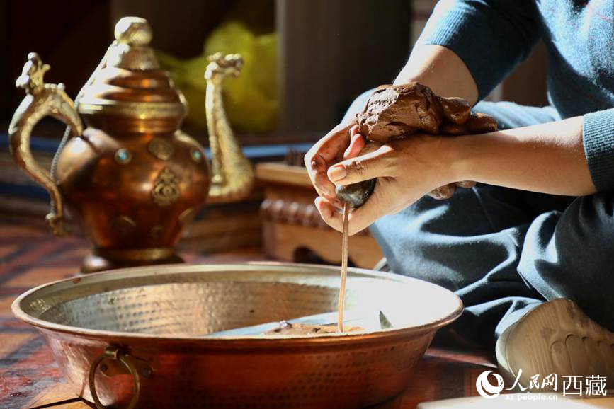 牛角鉆孔，將木泥擠出。人民網(wǎng)記者 次仁羅布攝