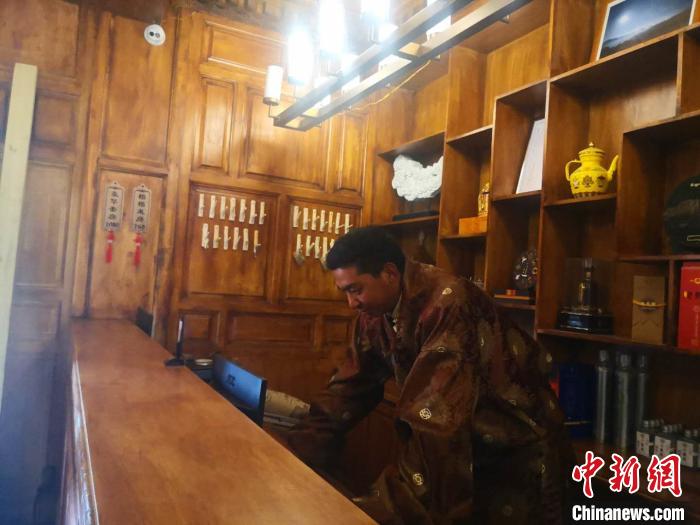 圖為桑杰才讓用電腦處理財(cái)務(wù)?！∈缝o靜 攝