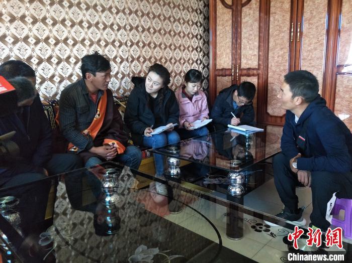 圖為調查組工作人員正在入戶調查?！∑钤鲚?攝