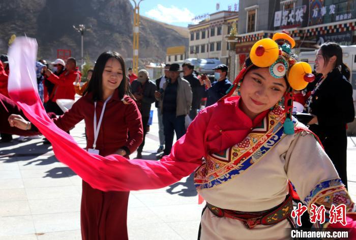 圖為中外記者向當(dāng)?shù)孛癖妼W(xué)習(xí)民族歌舞文化?！?zhí)砀?攝