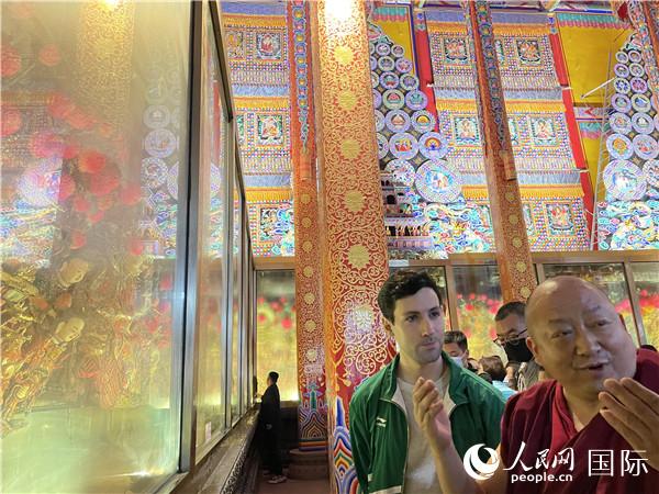 7月25日，省級非物質(zhì)文化遺產(chǎn)項目塔爾寺酥油花的代表性傳承人朋措堅參（右）在塔爾寺酥油花館講解酥油花的制作過程。人民網(wǎng) 謝瑩攝