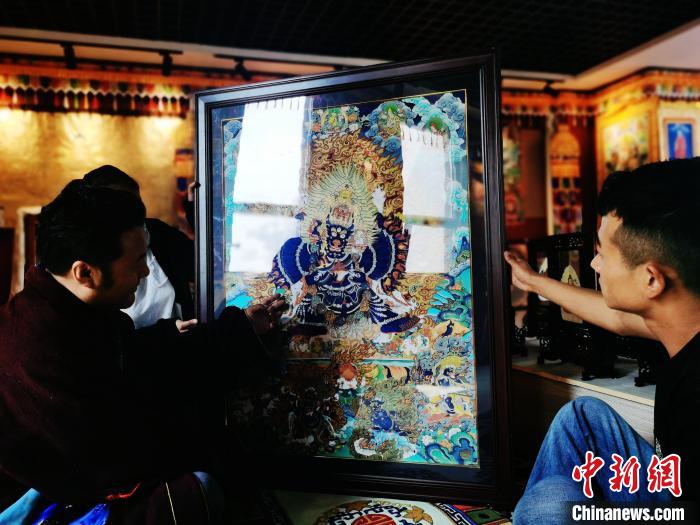圖為久美尖措(左)與徒弟們展示唐卡作品。　張?zhí)砀?攝