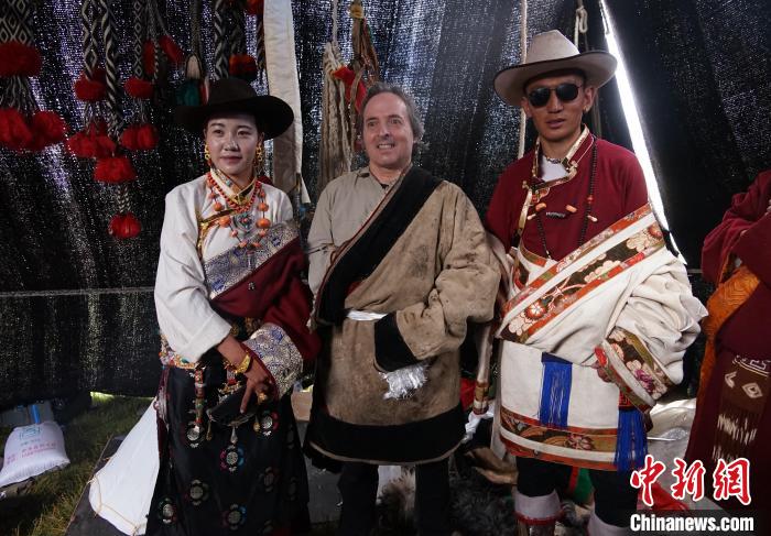 圖為一名外籍攝影師(中)身穿藏服和藏族民眾合影留念?！●R銘言 攝