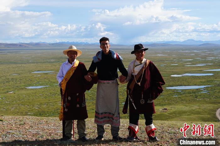 圖為一名留學生身穿自己國家的服飾和藏族民眾合影留念?！●R銘言 攝