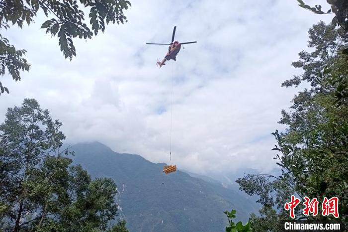 直升機起飛將搶修塔材運往海拔1950米的110千伏唐下線29號塔位。　徐慶明 攝
