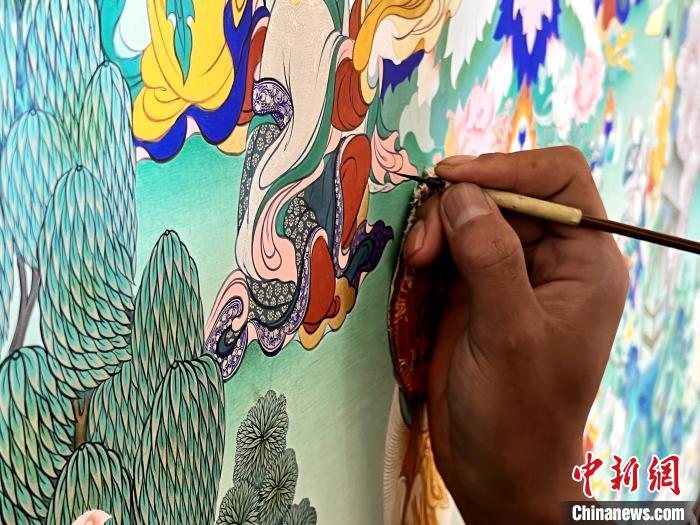圖為畫(huà)師繪畫(huà)唐卡。　馬文莉 供圖