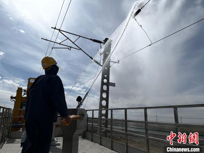 圖為高壓水槍的水柱沖洗絕緣子串?！「邌⒑?攝