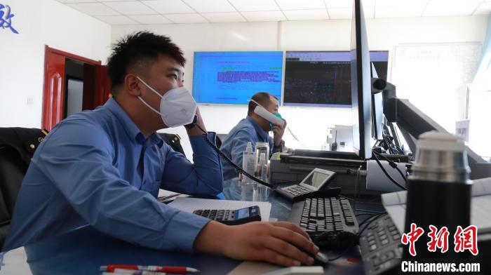 圖為貨運調(diào)度人員與外勤工作人員聯(lián)系掌握車輛裝載情況?！±钌?攝