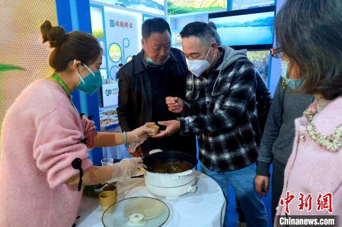 圖為杭州市民品嘗茶卡羊肉?！±铍h 攝