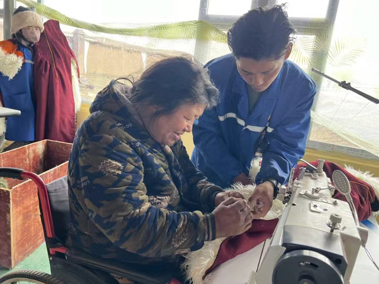 扎西奪爾登幫助殘疾員工裁剪。阿壩州文明辦供圖