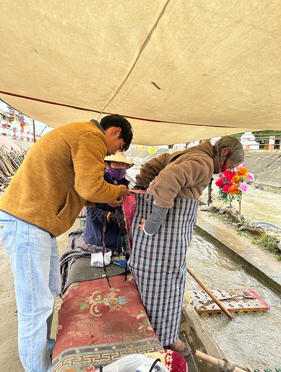 扎西奪爾登為路邊老人送去保暖圍腰。阿壩州文明辦供圖