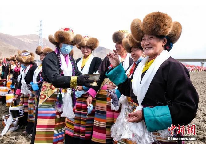 資料圖：西藏自治區(qū)拉薩市曲水縣才納鄉(xiāng)協(xié)榮村參加春耕儀式的村民互敬青稞酒。按照傳統(tǒng)，當(dāng)?shù)卮迕裆碇?jié)日盛裝，舉行隆重的儀式，祈福一年的豐收。<a target='_blank' ><p  align=