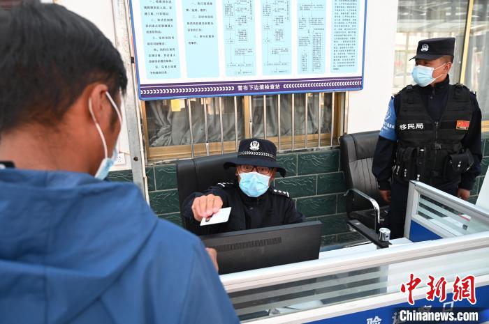 圖為移民管理警察登記完身份信息后將證件歸還給行人。　趙朗 攝