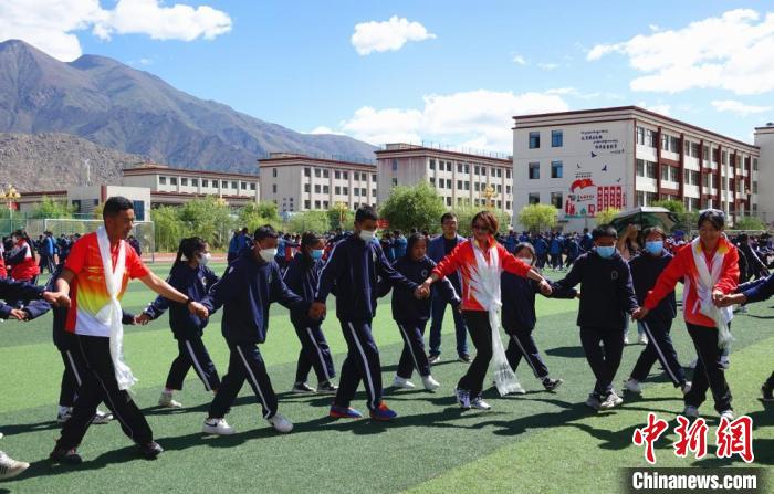 圖為世界冠軍與拉薩阿里地區(qū)高級中學學生一起跳鍋莊?！∪轿木?攝