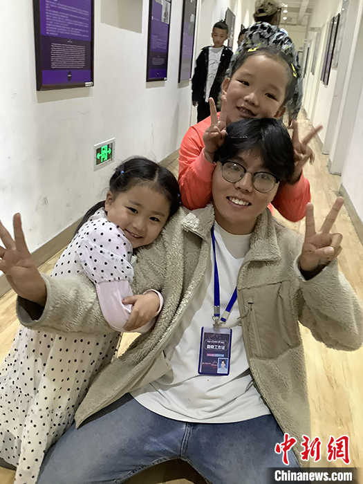 “Z世代”旦真旺加認為，拉薩是一座開放與包容的城市，記憶中的拉薩是彩色的。2021年，旦真旺加從浙江大學漢語言文學專業(yè)畢業(yè)后，他選擇回到拉薩，成為一名漢語文實習助教。圖為8月4日，旦真旺加在課間陪學生玩耍。 <a target='_blank' ><p  align=