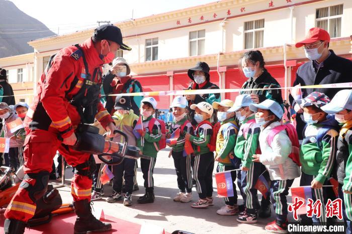 圖為消防指戰(zhàn)員為學(xué)生講解、演示先進(jìn)救援裝備。　趙琳 攝
