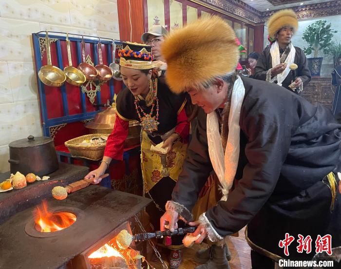 圖為人們?cè)诨鹕峡竟?jié)日美食“結(jié)達(dá)”?！∪轿木?攝