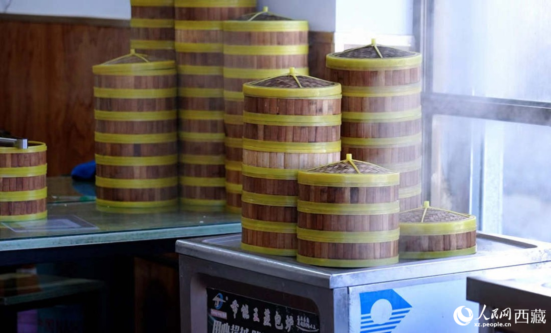 電蒸箱上擺滿了多屜熱氣騰騰的包子。人民網(wǎng) 次仁羅布攝