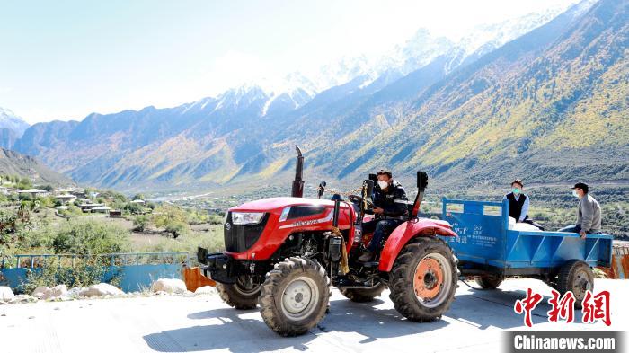 圖為工作人員將把加工完成的糌粑運送至村民手中?！〖卫杩h融媒體中心供圖