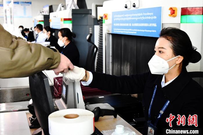 圖為機(jī)場工作人員為旅客辦理行李托運(yùn)?！≈芎?攝