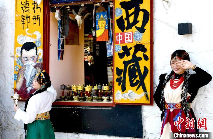 4月17日，游客身著藏式元素服裝在拉薩八廓街拍照留念?！±盍?攝