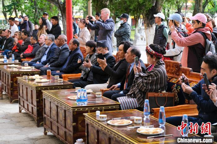 5月19日，中外嘉賓在羅布林卡和游客一起觀看藏戲?！〗w波 攝