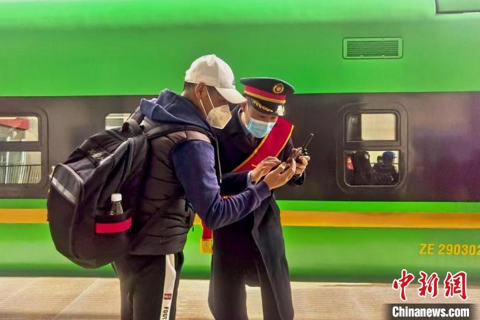 圖為日喀則火車站工作人員服務(wù)乘客?！《飞降?攝