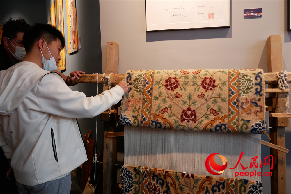 觀眾正在觀賞展出的藏毯。人民網(wǎng) 韋衍行攝