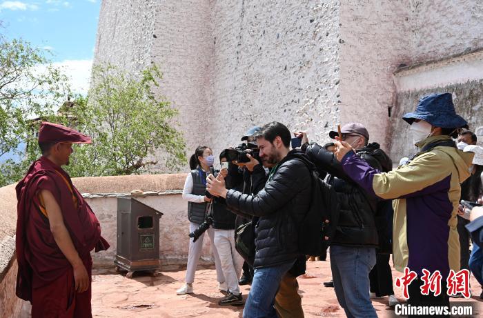 圖為中外媒體拍攝朝拜布達(dá)拉宮的僧人。　趙朗 攝