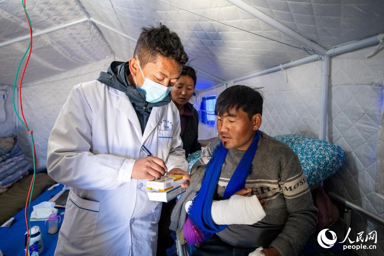 　醫(yī)生正在囑咐洛桑堅(jiān)參如何用藥。人民網(wǎng)記者 翁奇羽攝