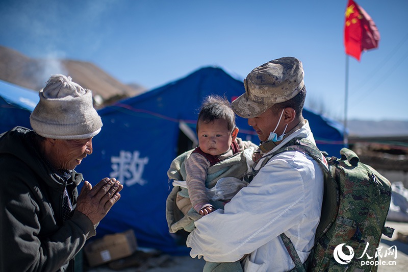 1月9日，在定日縣長(zhǎng)所鄉(xiāng)古榮村安置點(diǎn)，受災(zāi)群眾感謝西藏軍區(qū)陸軍某部隊(duì)衛(wèi)生員的醫(yī)療救治。人民網(wǎng)記者 翁奇羽攝