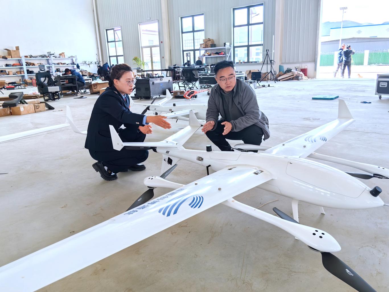 創(chuàng)博通航工作人員向稅務(wù)干部介紹無人機情況。曲麗攝