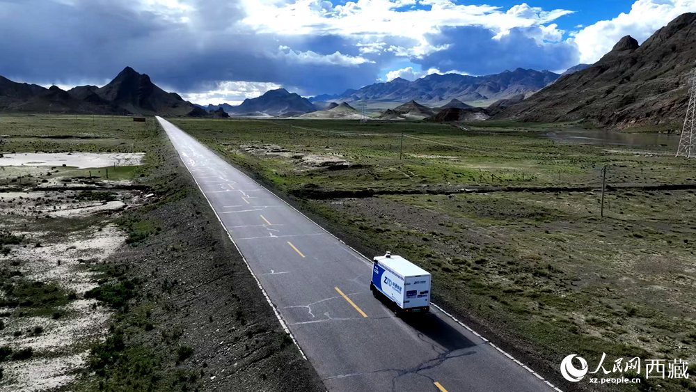 一輛無人快遞車正沿著定日縣通往扎果鄉(xiāng)的道路平穩(wěn)行駛。人民日?qǐng)?bào)記者 鮮敢攝
