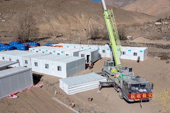 2025年1月9日，在定日縣長所鄉(xiāng)古榮村安置點(diǎn)，救援人員和施工人員合力抓緊搭建移動(dòng)板房，確保受災(zāi)群眾溫暖過冬。人民網(wǎng)記者 翁奇羽攝