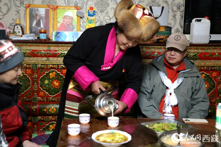 扎西曲登社區(qū)的居民在家中熱情招待遠道而來的游客。居民身著盛裝，為游客倒上熱騰騰的酥油茶，桌上擺放著切瑪與特色美食，賓主共話民族團結(jié)情誼。人民網(wǎng)記者 吳雨仁攝