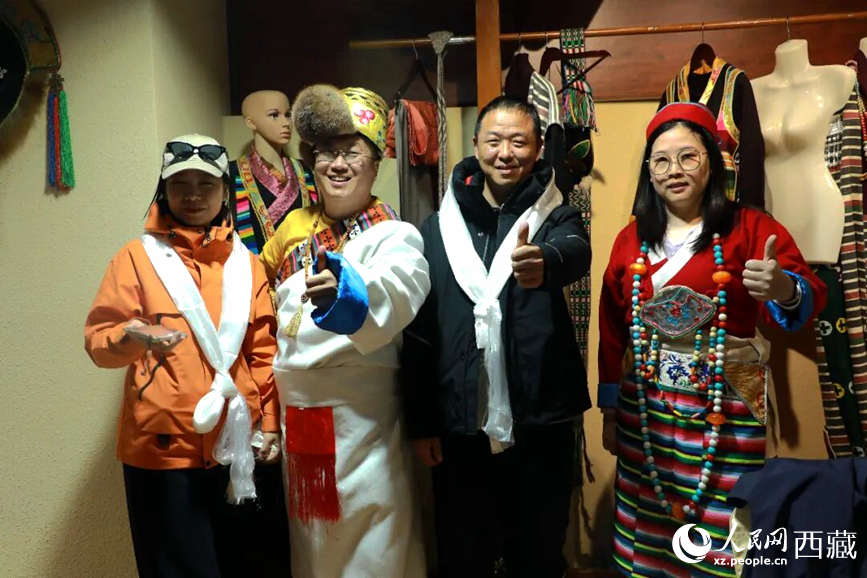 游客在扎西曲登社區(qū)體驗藏族服飾文化。大家身著色彩鮮艷的藏裝，佩戴特色飾品，臉上洋溢著喜悅的笑容。人民網(wǎng)記者 吳雨仁攝