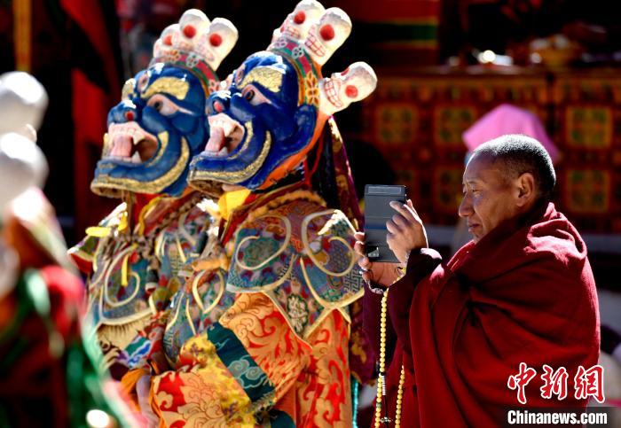 2月19日，正在拍攝跳神活動的僧人?！±盍?攝