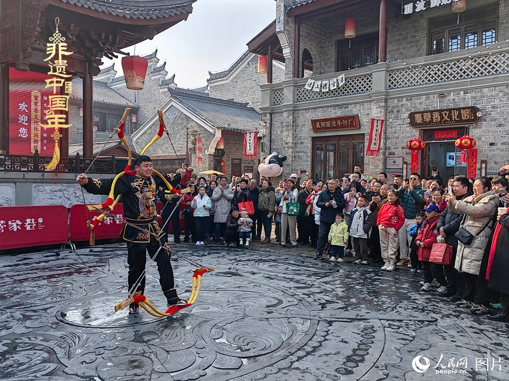 2025年1月29日，湖北襄陽市管家巷，老北京天橋大刀張舉大刀拉硬弓第五代傳承人現(xiàn)場表演，一次拉開6張弓，引來游客喝彩。人民網(wǎng)記者 郭婷婷攝